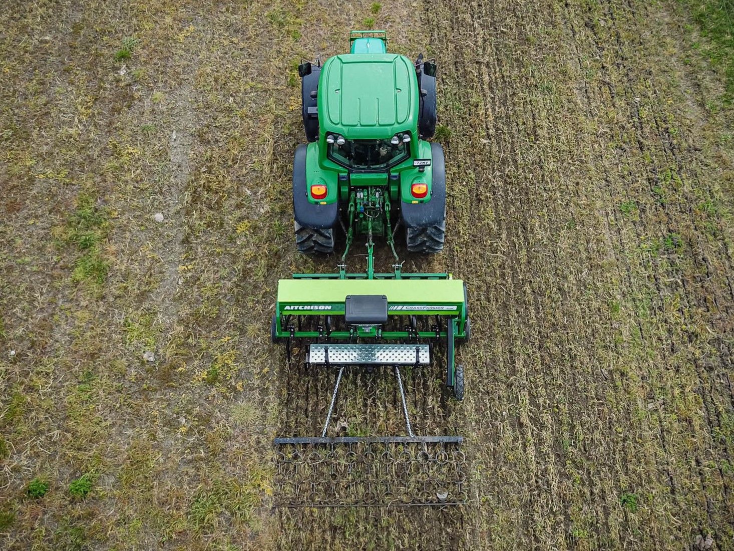 Aerial view of the Aitchison GrassFarmer® 3018C with tread board and harrow upgrades visible as it drills across a pasture paddock.